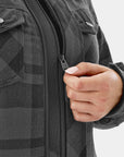 Person wearing a gray checkered jacket with a hand on the zipper