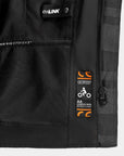 Close-up of a black jacket with visible branding and labels on a gray background