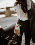 colourful leather motorcycle lady gloves from Wildust hanging from a woman's jeans back pocket