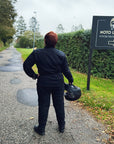 a back of woman motorcyclist wearing black jeans and mc jacket