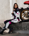 Young woman wearing black, white, pink SHIMA motorcycle  leather suit with her red motorcycle