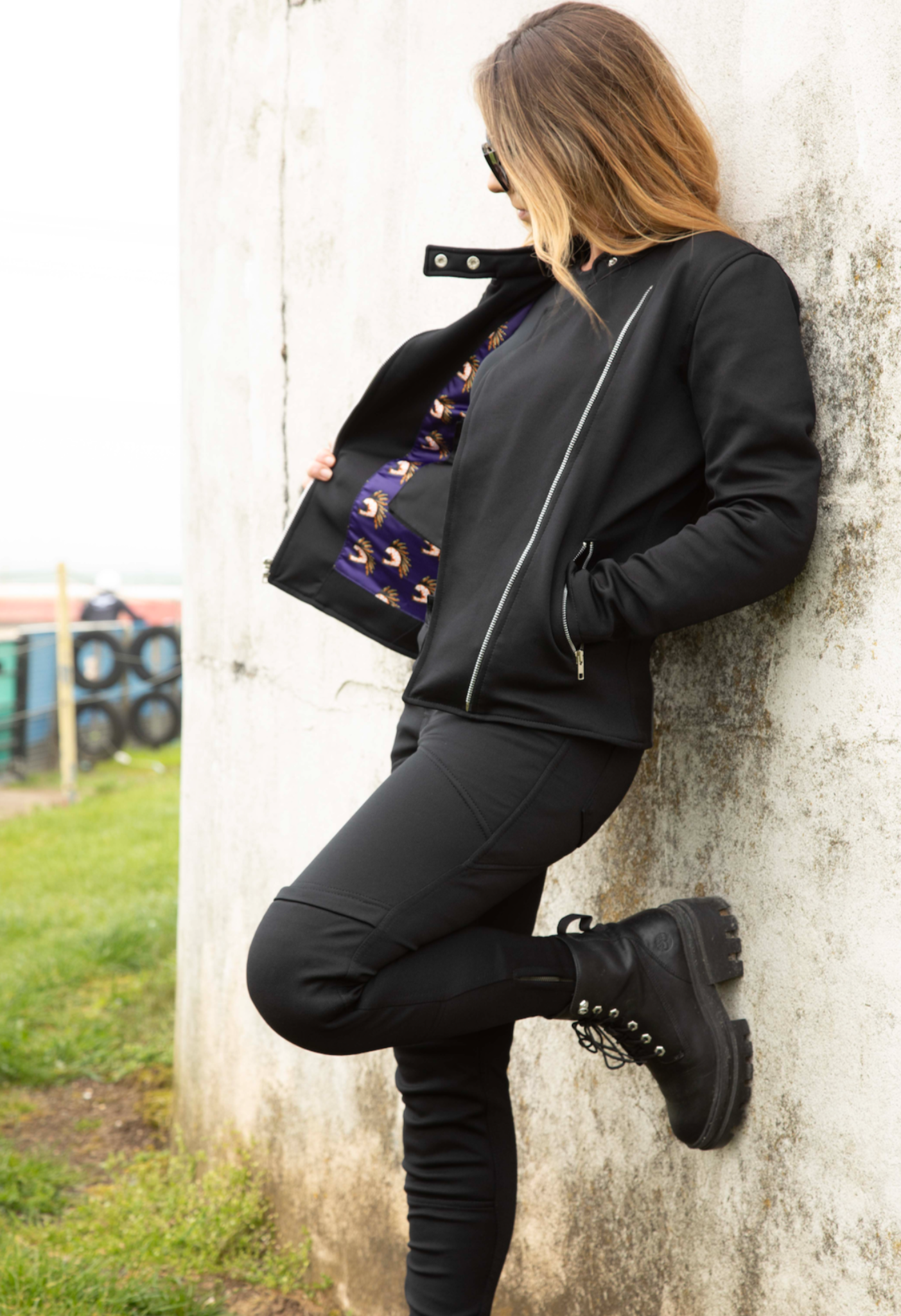 A woman wearing black mc jacket and black womens motorcycle pants with a front zip from Moto Girl