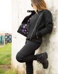 A woman wearing black mc jacket and black womens motorcycle pants with a front zip from Moto Girl