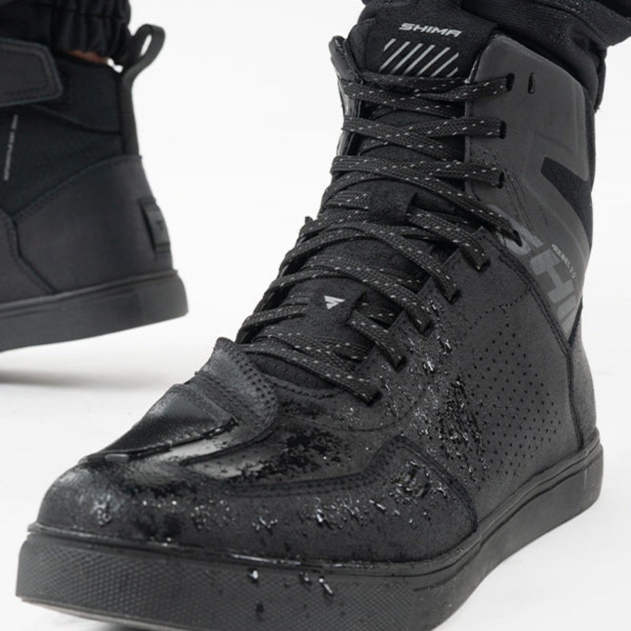 Rebel waterproof motorcycle sneakers with black laces from Shima from the front with water on