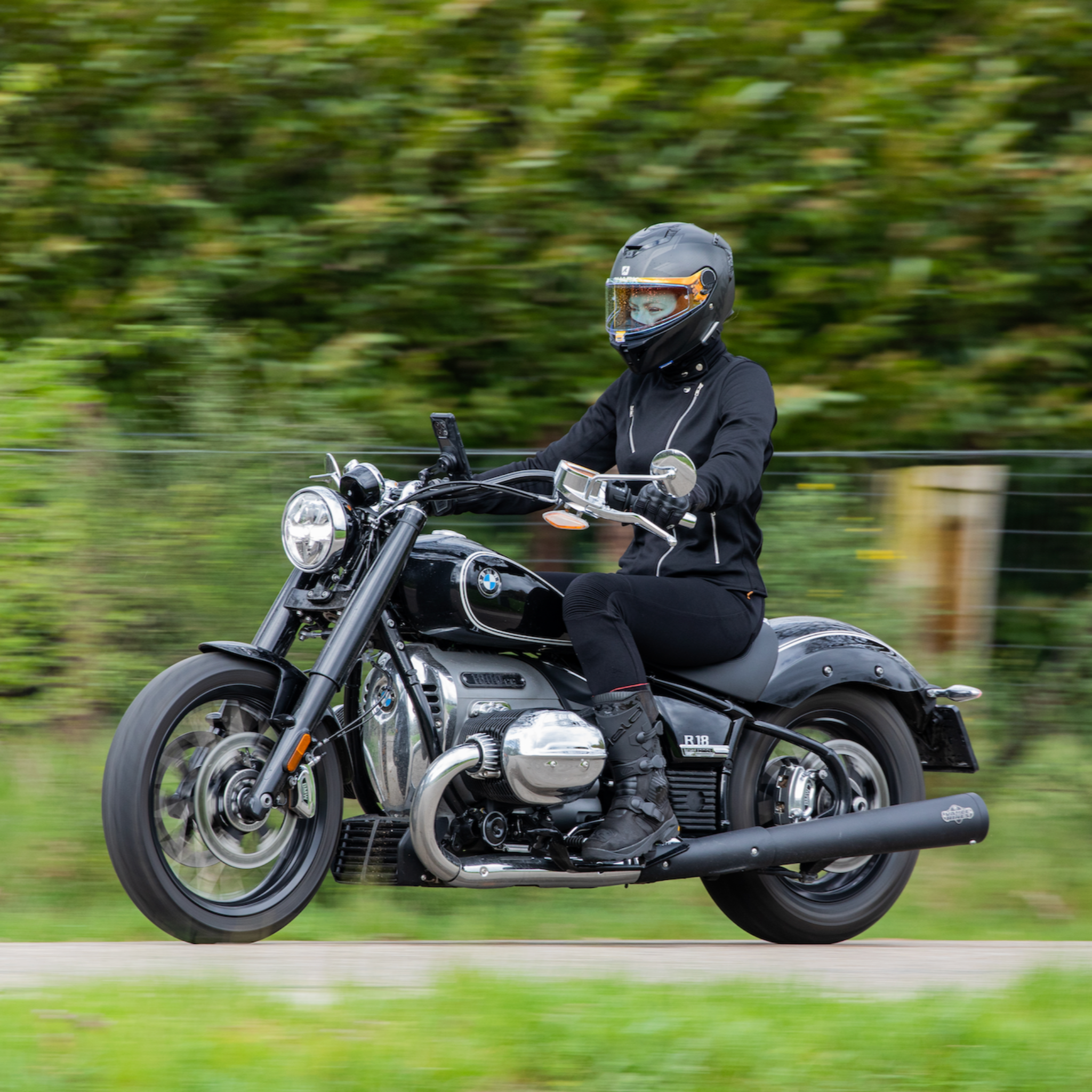 woman driving a motorcycle wearing Black retro style woman's motorcycle jacket with silver zip details