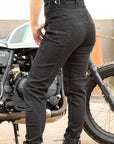 women's standing by a motorcycle  legs  wearing black mc jeans with high waist