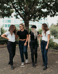 Four smiling women wearing black and blue women’s motorcycle jeans from Moto Girl.