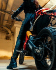 A woman on a motorcycle wearing black and green women's motorcycle leggings from exagon66