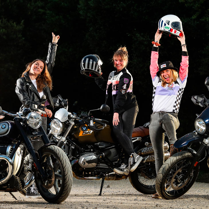 Three young ladies with motorcycles