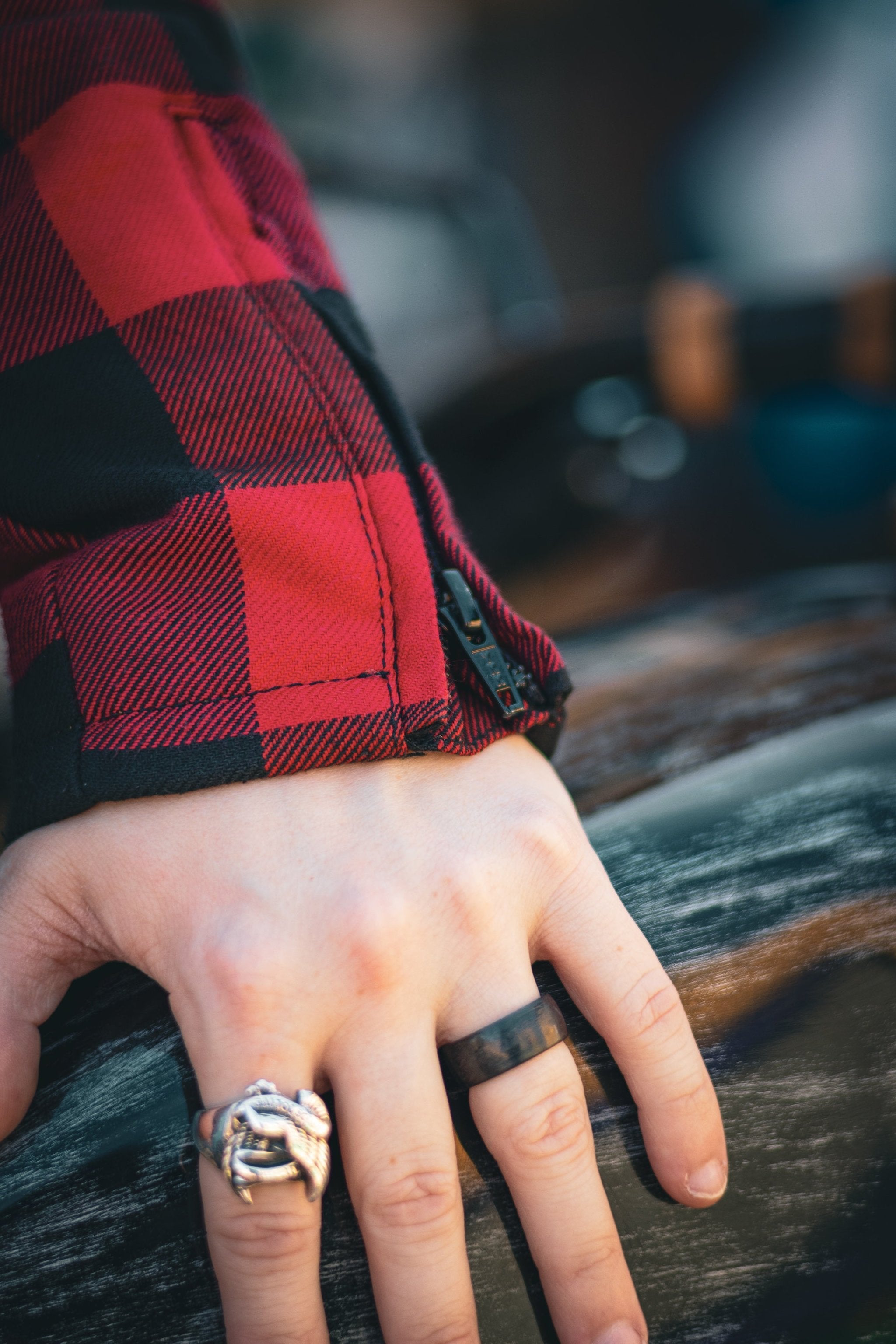 close up of sleeve with zipper detail on red and black flannel-style women&#39;s jacket from moto girl