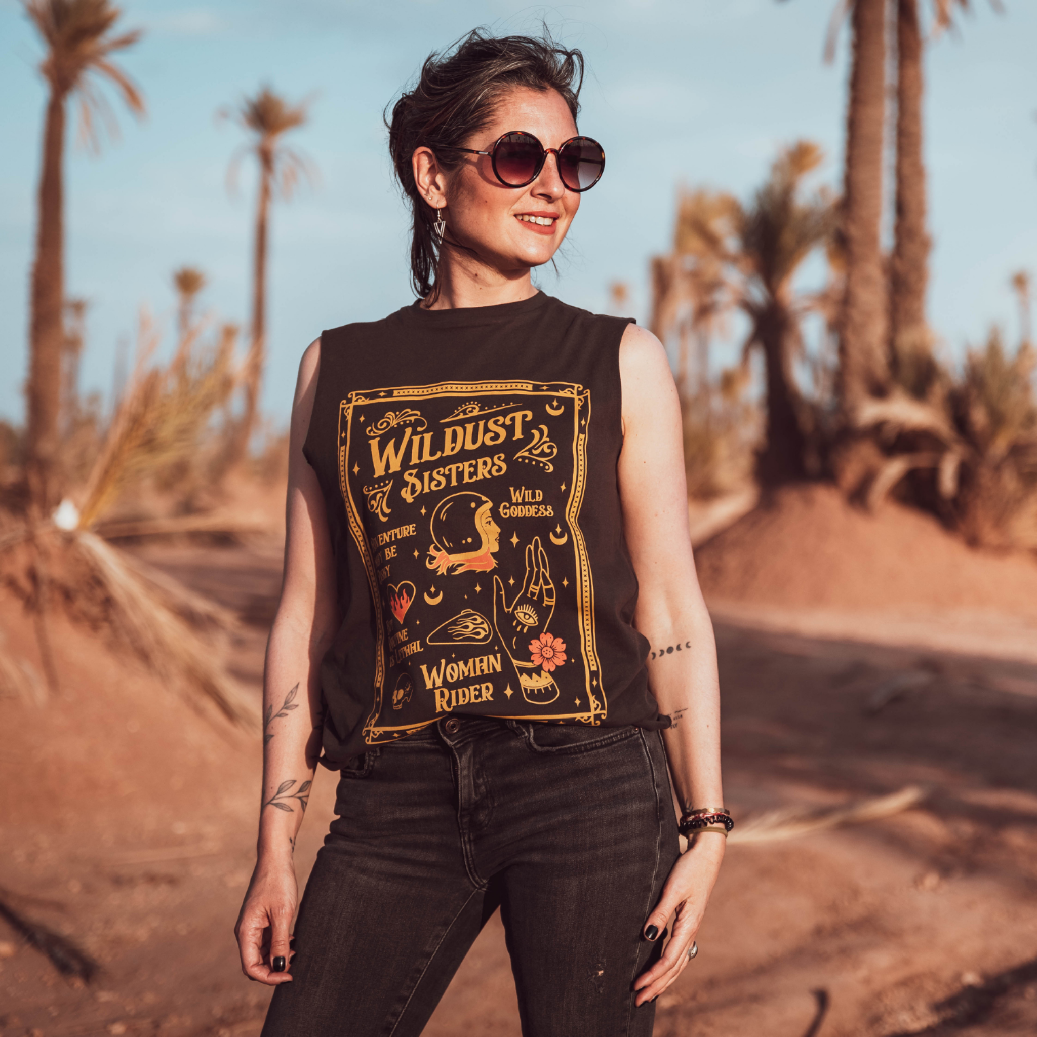 Woman wearing black t-shirt with a woman wearing a Motorcycle helmet with the text &quot;Wildust sister&quot; 