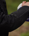a close up of a woman's hand on a motorcycle mirror showcasing the sleeve of her black mesh jacket