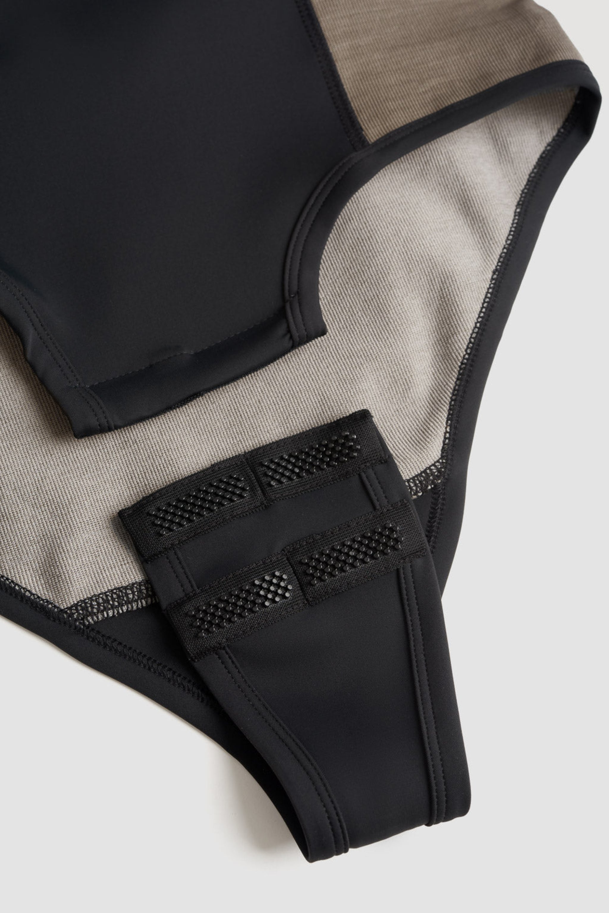 crotch closure of a Black and grey moto bodysuit
