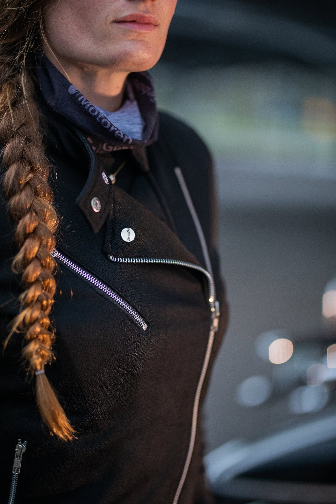 woman wearing Black retro style woman&#39;s motorcycle jacket with silver zip details