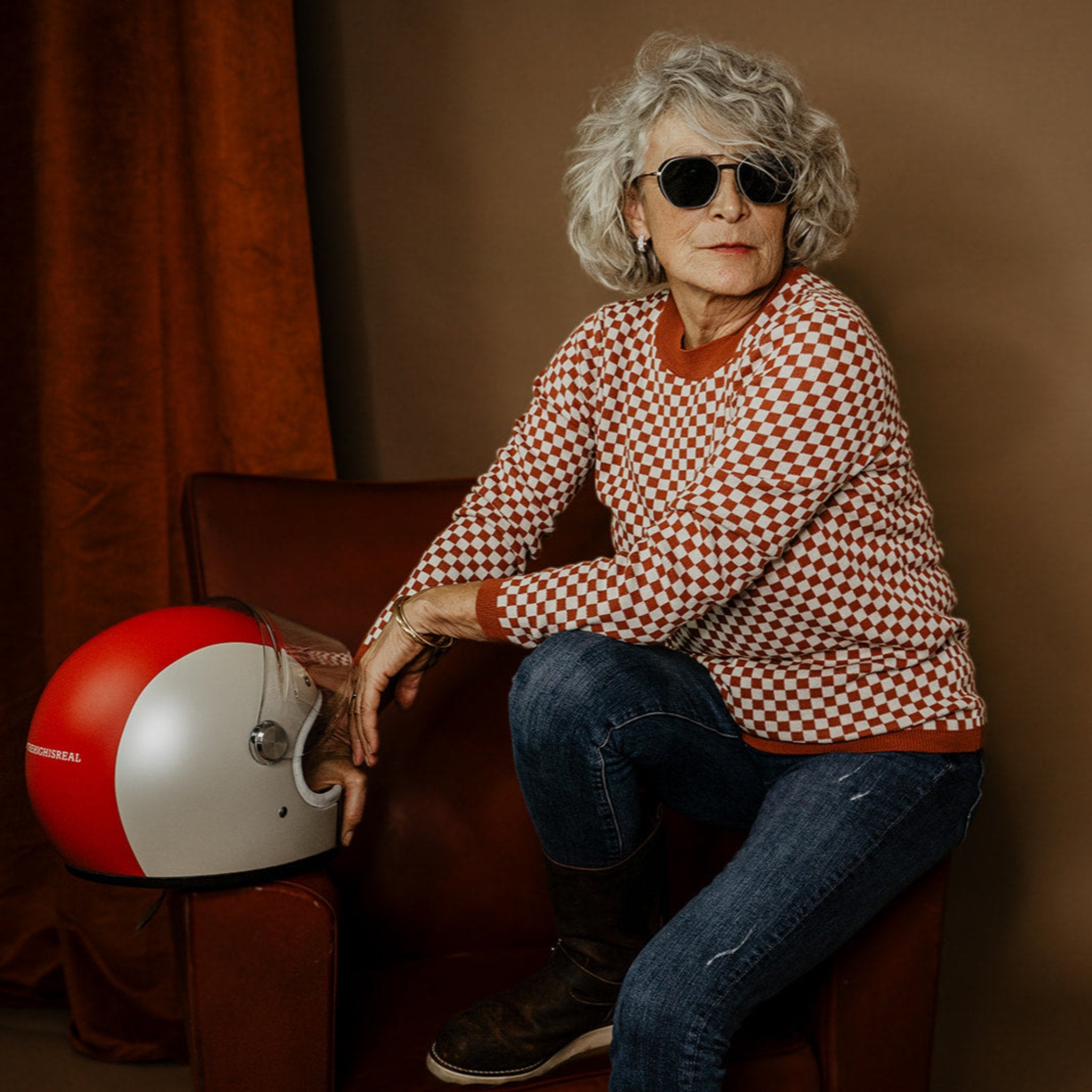 an older lady wearing a knitted red and white jumper with chessboard motives from Wildust