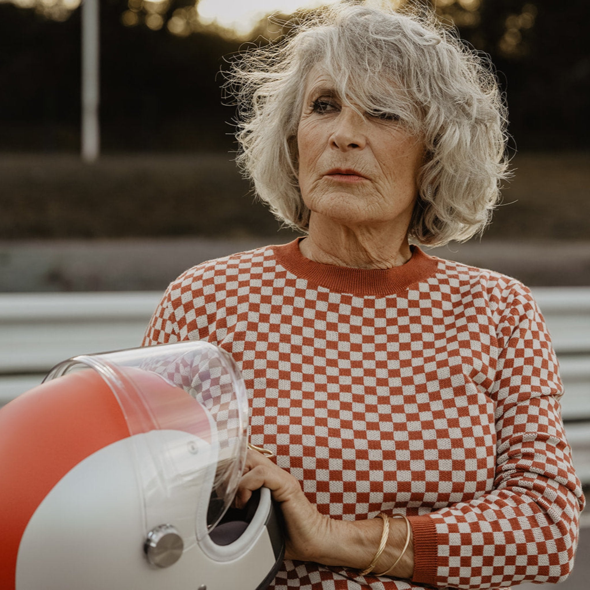 an older lady wearing a knitted red and white jumper with chessboard motives from Wildust