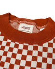 a collar of a knitted red and white jumper with chessboard motives from Wildust