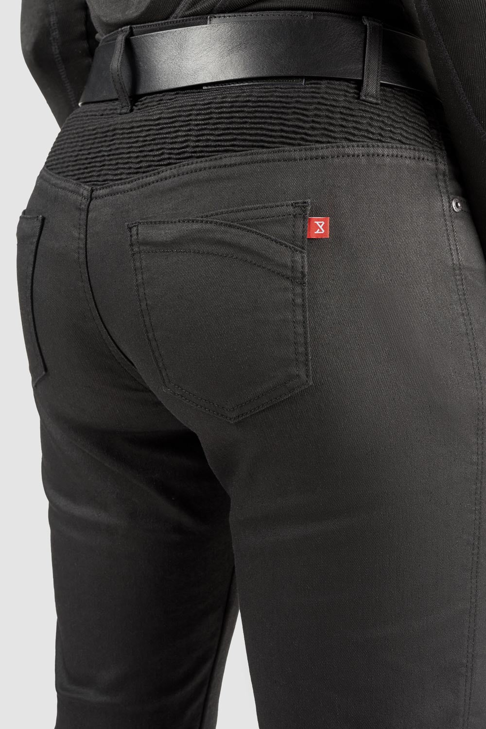 Black mc pants with a red label on the back pocket against a white background