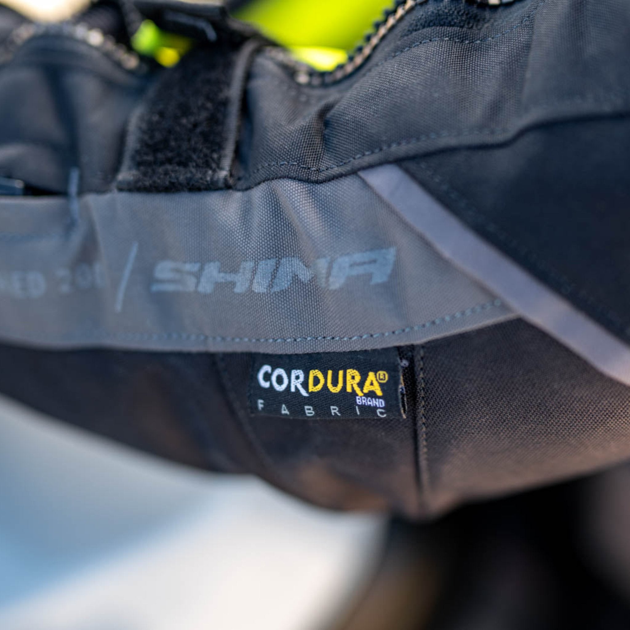 A close up of the Cordura fabric label on the shima motorcycle touring jacket for women in black/ fluo