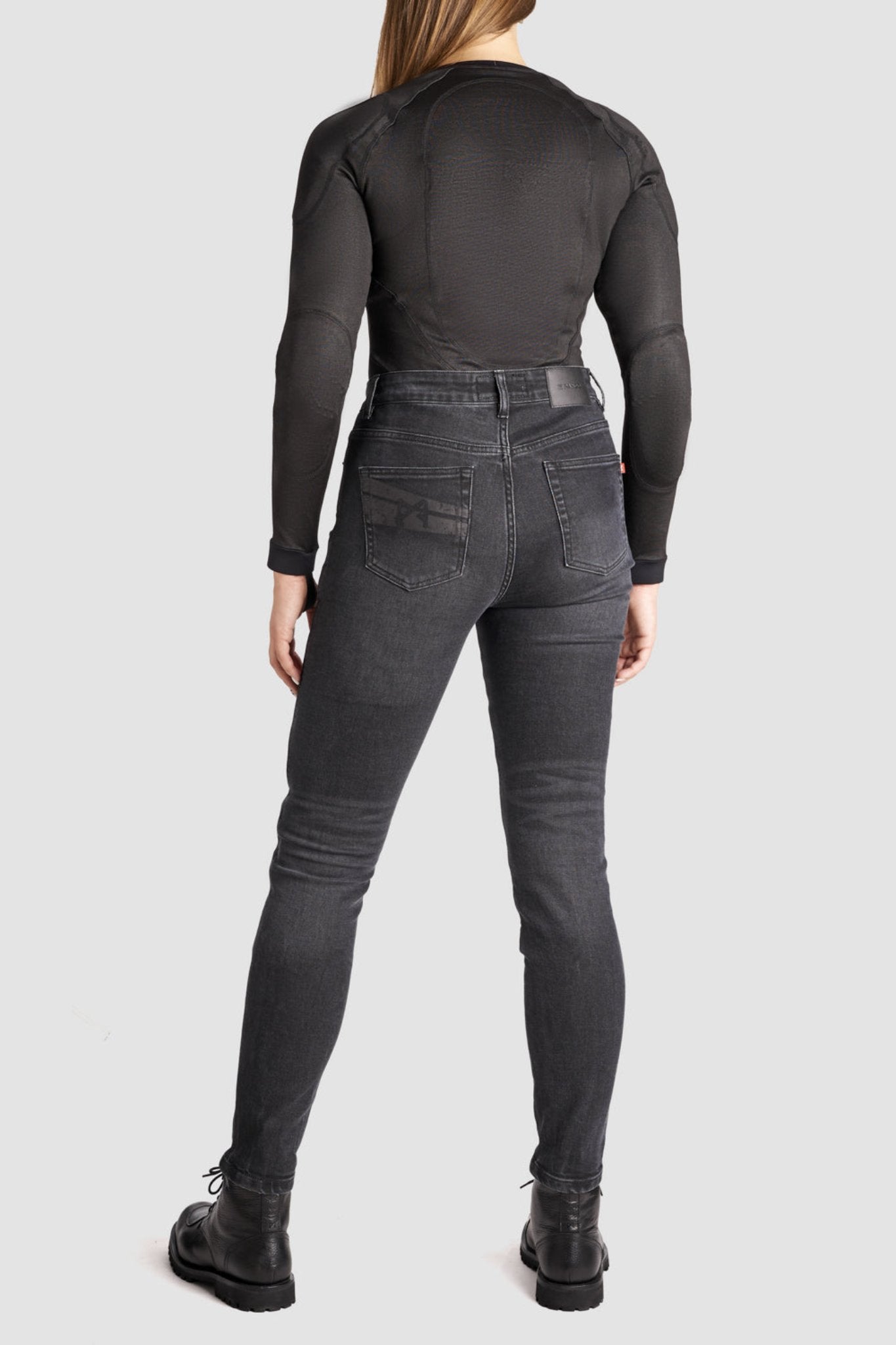 a woman back wearing black jeans and black motorcycle body suit from Pando Moto 