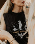 a young blong woman putting her lipstick on and wearing tank top with motorcycle motives