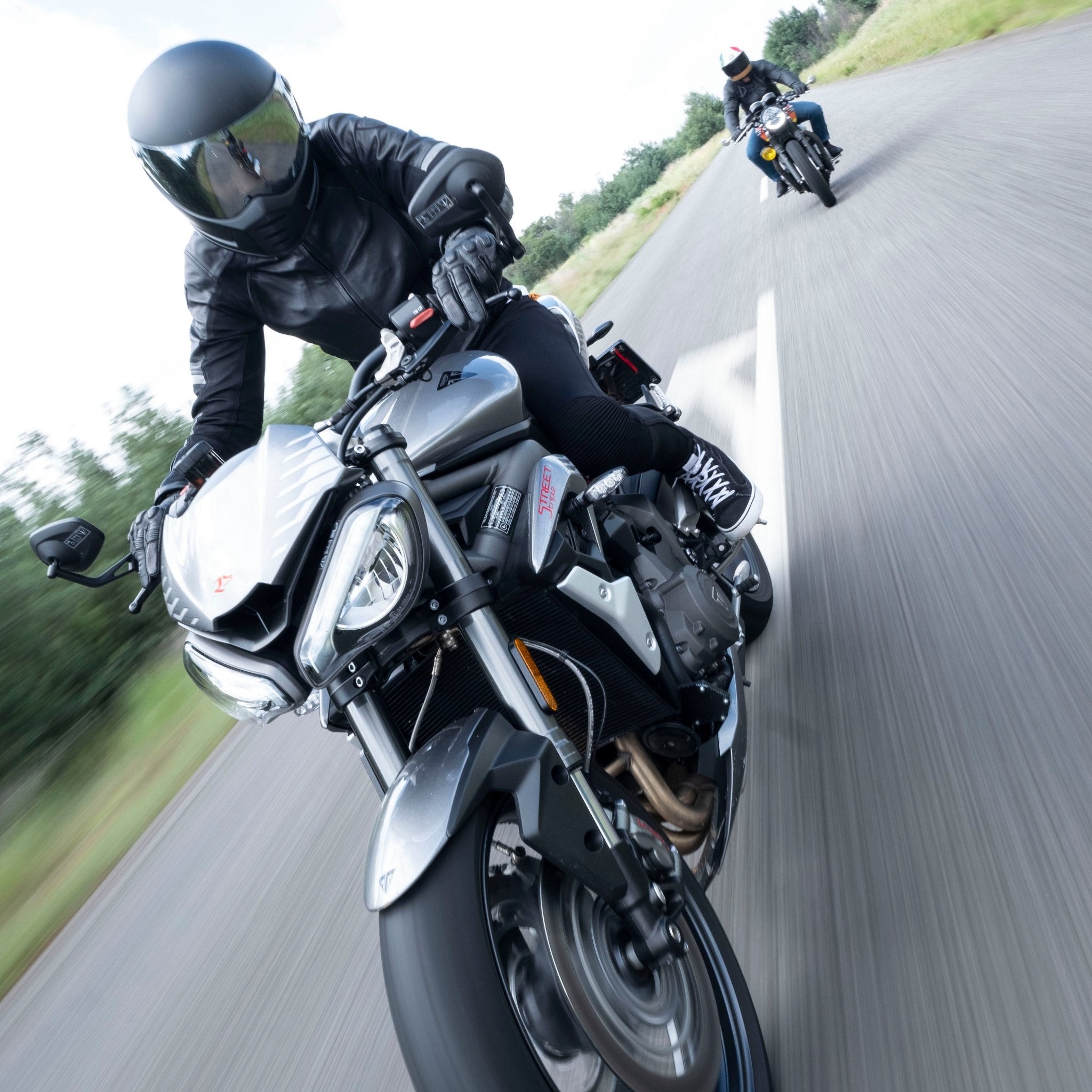 A woman driving a motorcycle wearing Black leather women&#39;s motorcycle jacket with reflectors from Moto Girl 