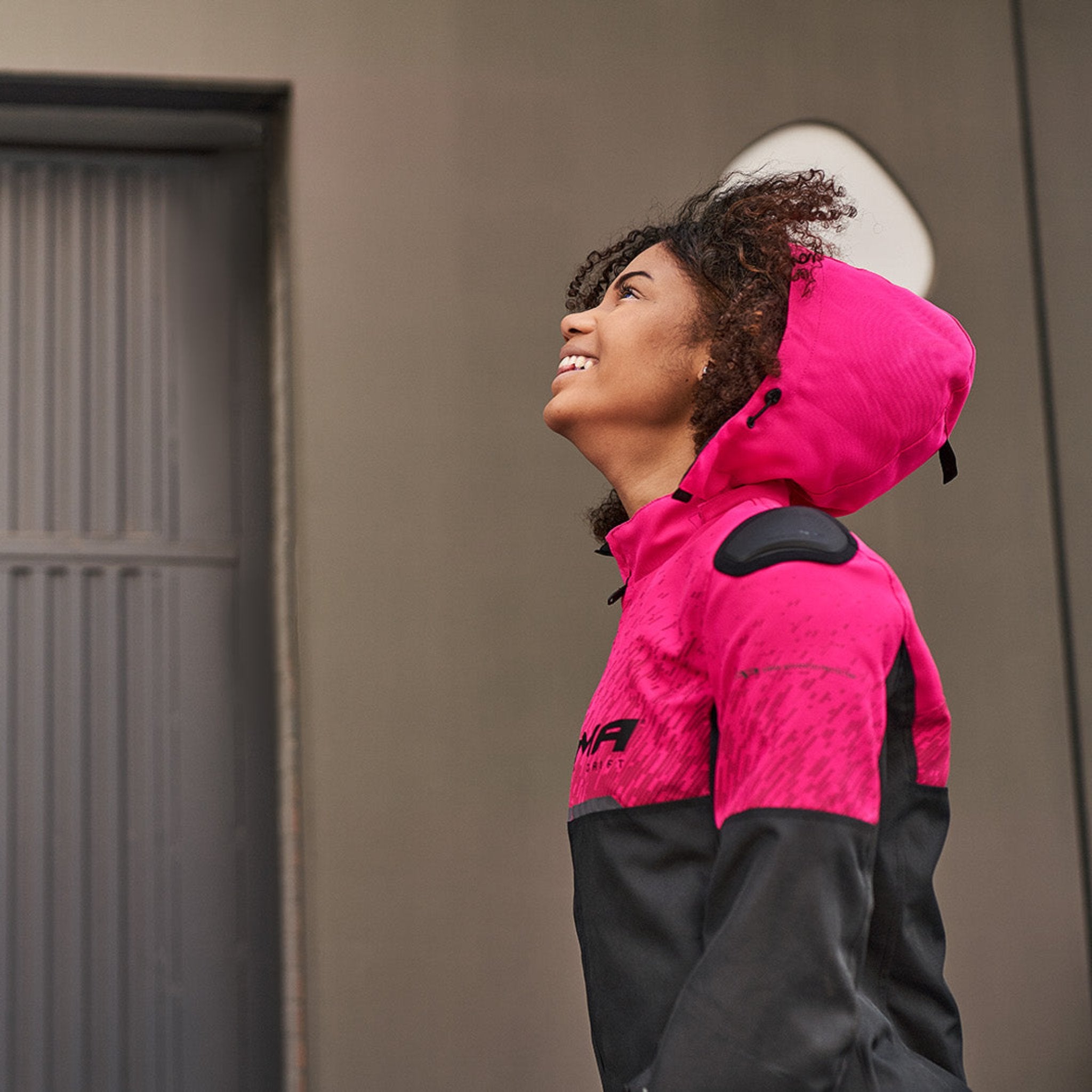 a smiling woman wearing pink DRIFT  motorcycle jacket from Shima with a hood