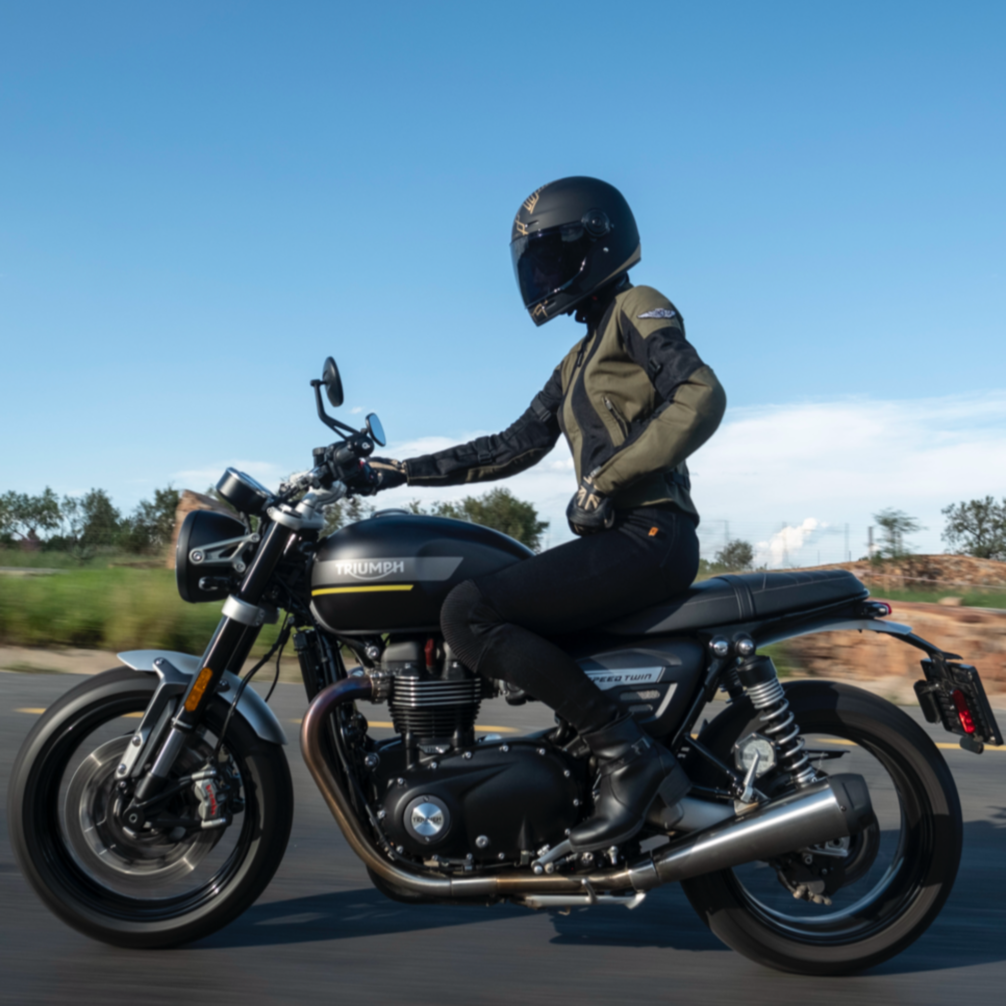 A woman on a motorcycle wearing women&#39;s motorcycle summer mesh jacket in black and green from Moto Girl