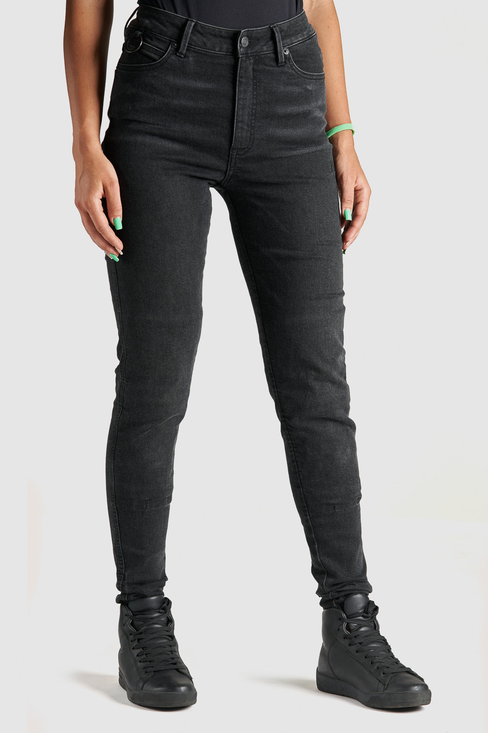 woman&#39;s legs wearing black high waist motorcycle jeans