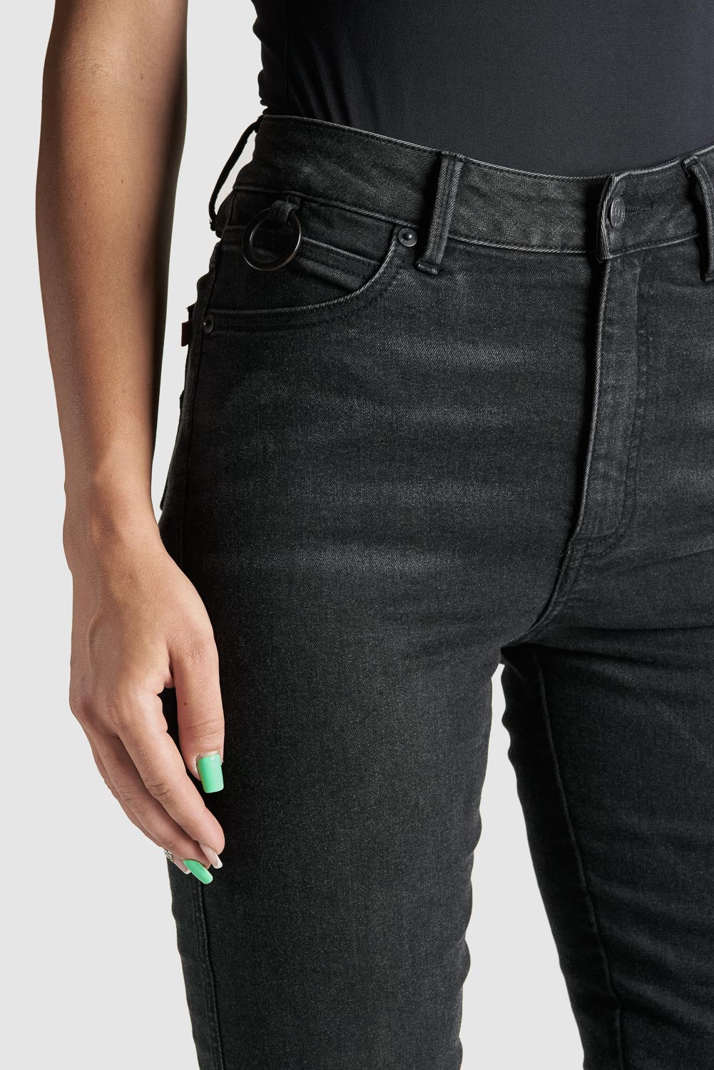 A close up of woman&#39;s waist wearing black high waist motorcycle jeans