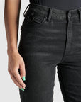 A close up of woman's waist wearing black high waist motorcycle jeans