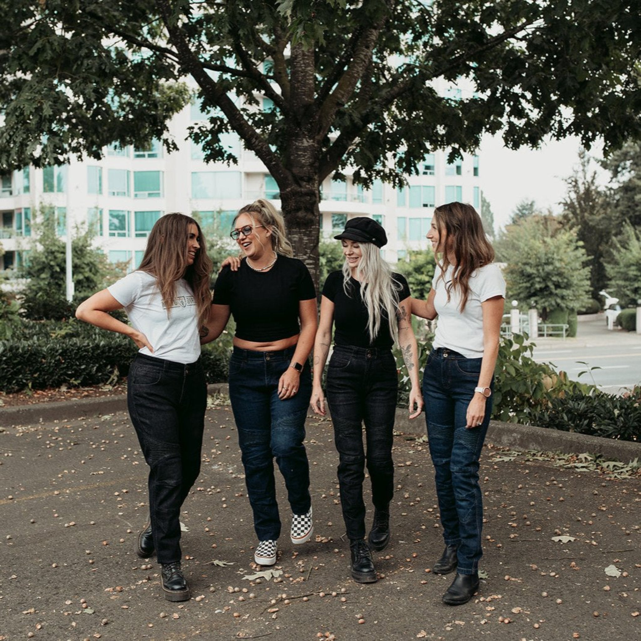 Four smiling women wearing black and blue women’s motorcycle jeans from Moto Girl.