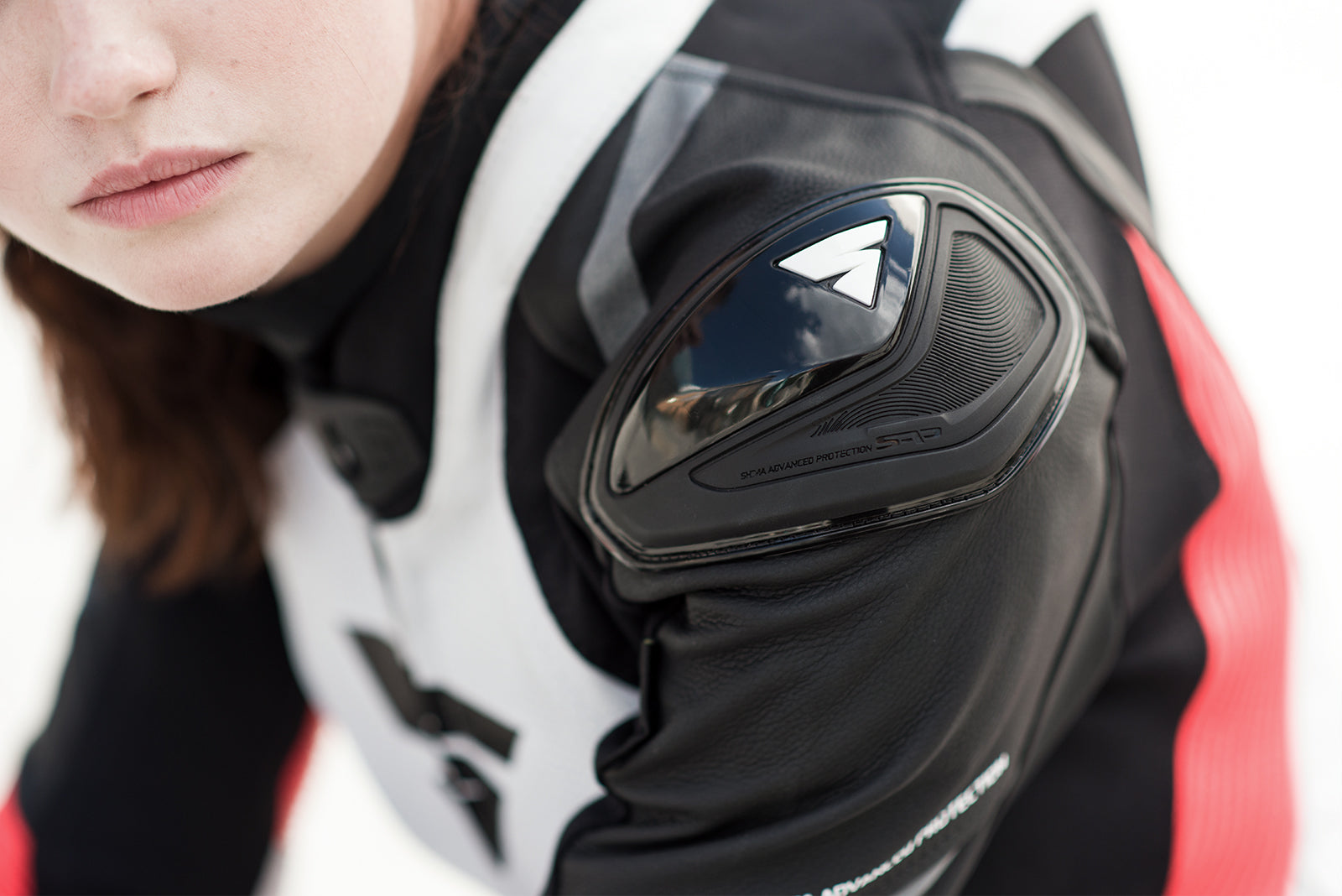 A close up of woman's shoulder wearing Women's racing suit MIURA RS in black, white and fluo from Shima 