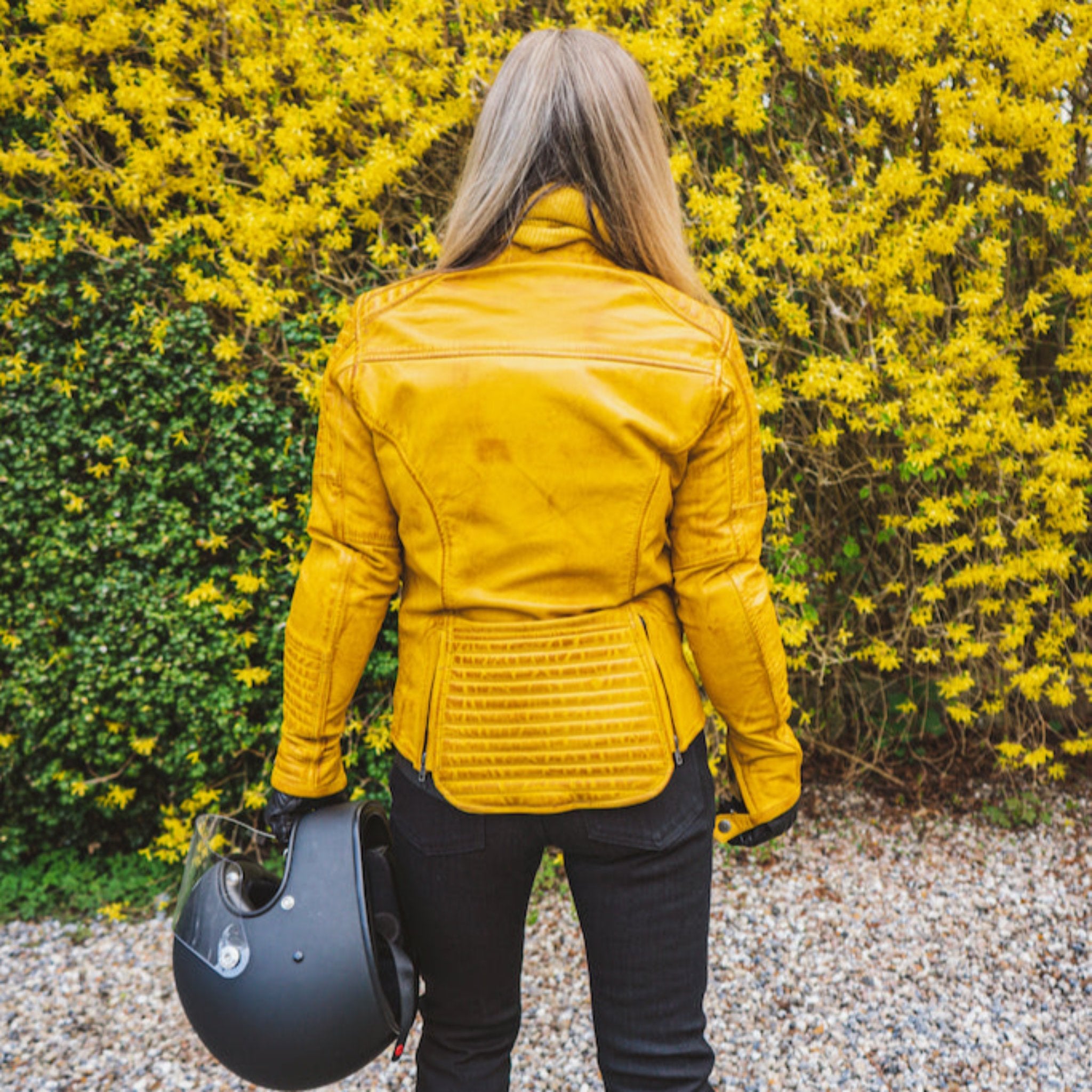 Woman&#39;s back wearing yellow women&#39;s motorcycle jacket