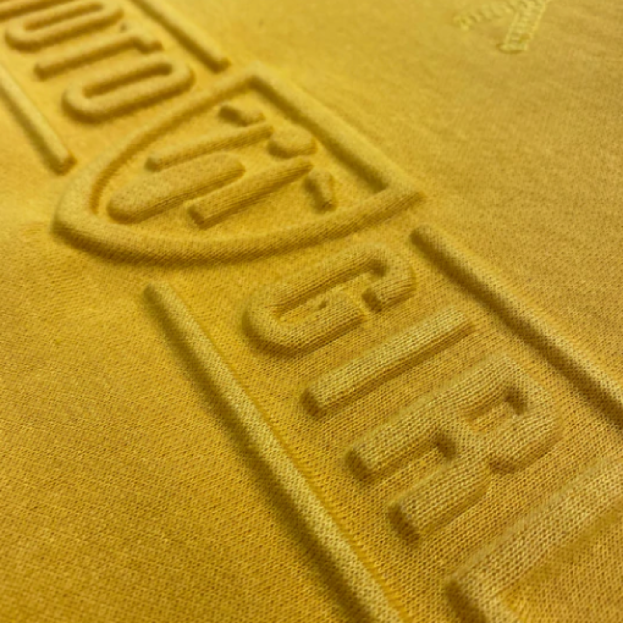 A close up of the 3d logo on a women&#39;s motorcycle sweatshirt from Moto Girl in mustard color