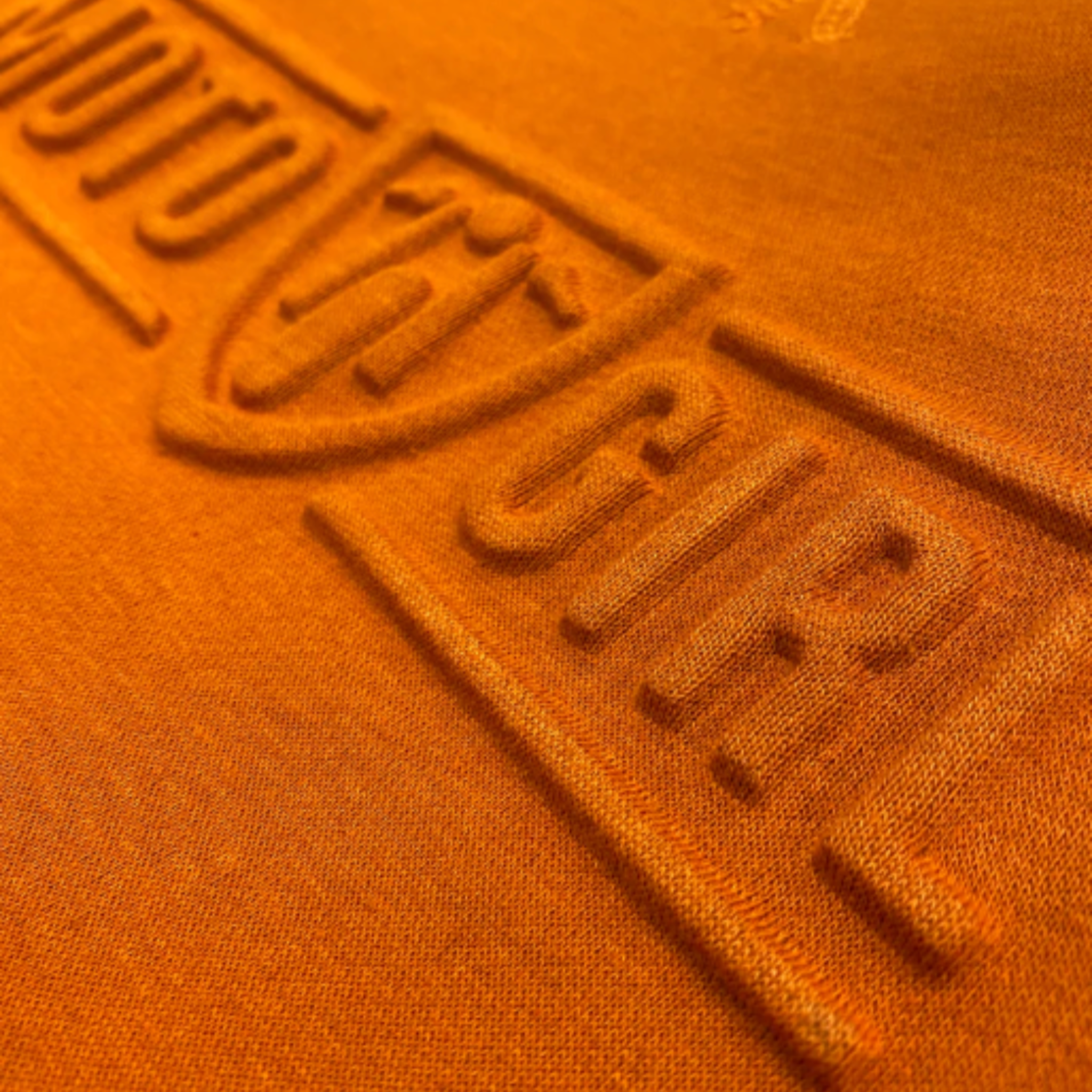 A close up of the 3d logo on a women&#39;s motorcycle sweatshirt from Moto Girl in the color burnt orange