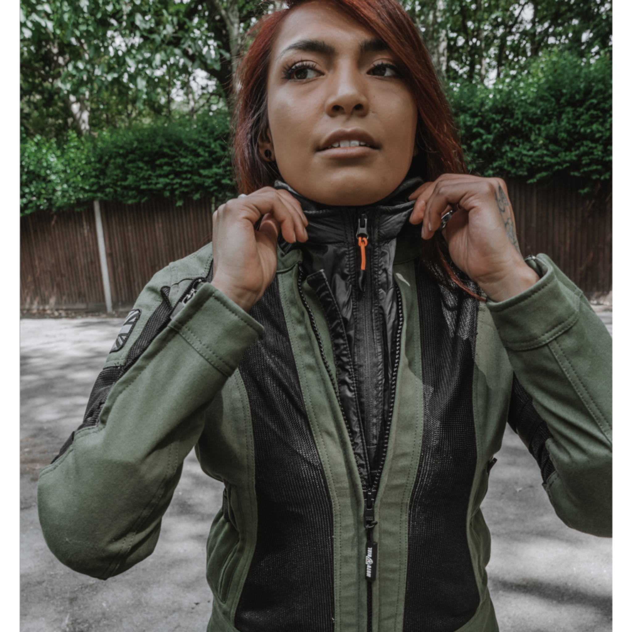 A woman wearing green and black mesh motorcycle jacket and a wind stop jacket