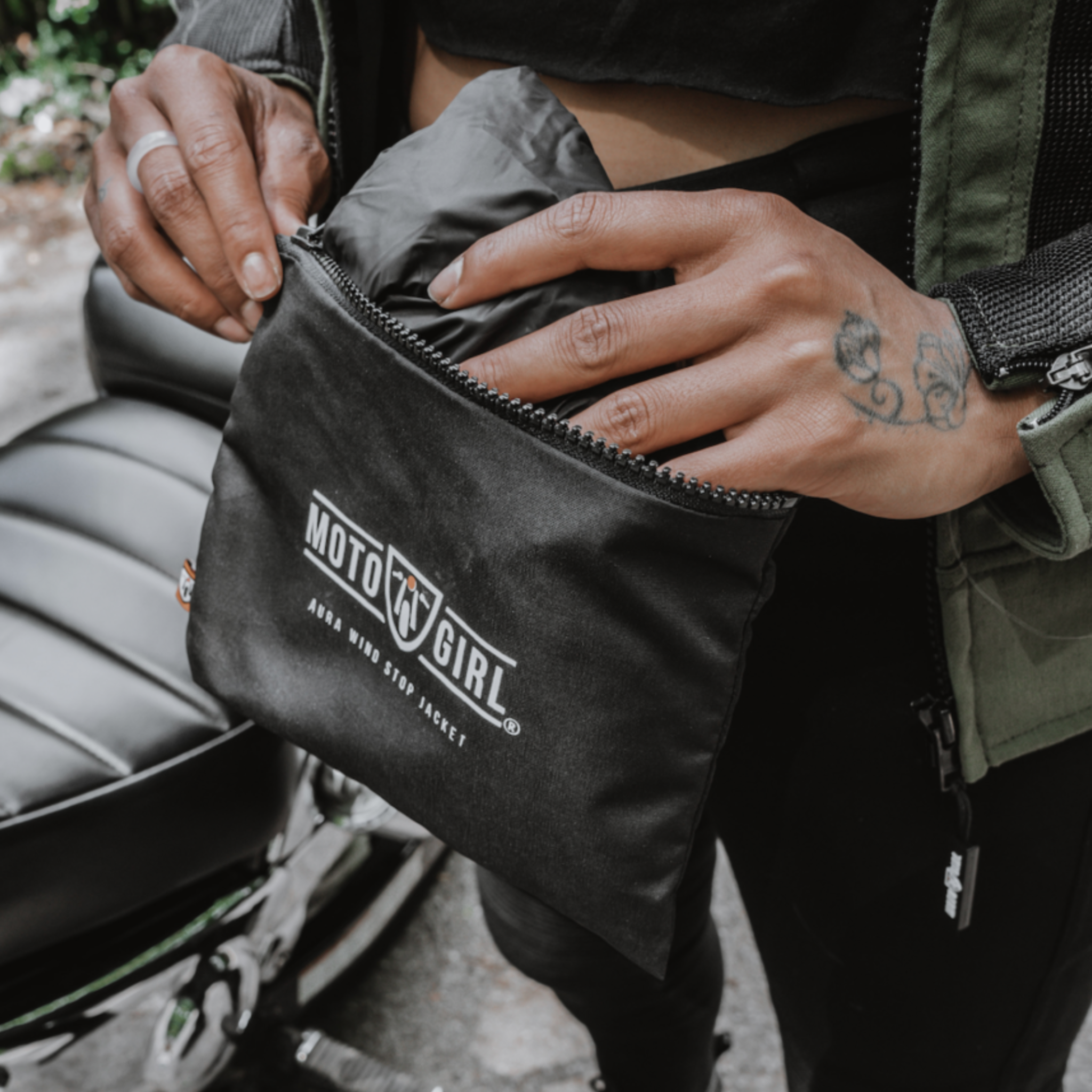 Women&#39;s hands taking out a jacket from the bag with Moto Girl logo