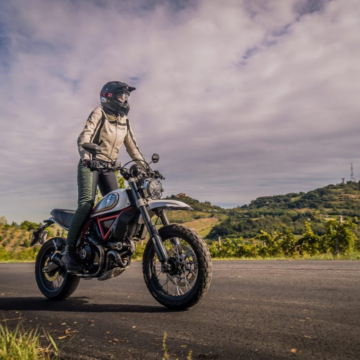 A woman on a motorcycle wearing black and green women's motorcycle leggings from exagon66