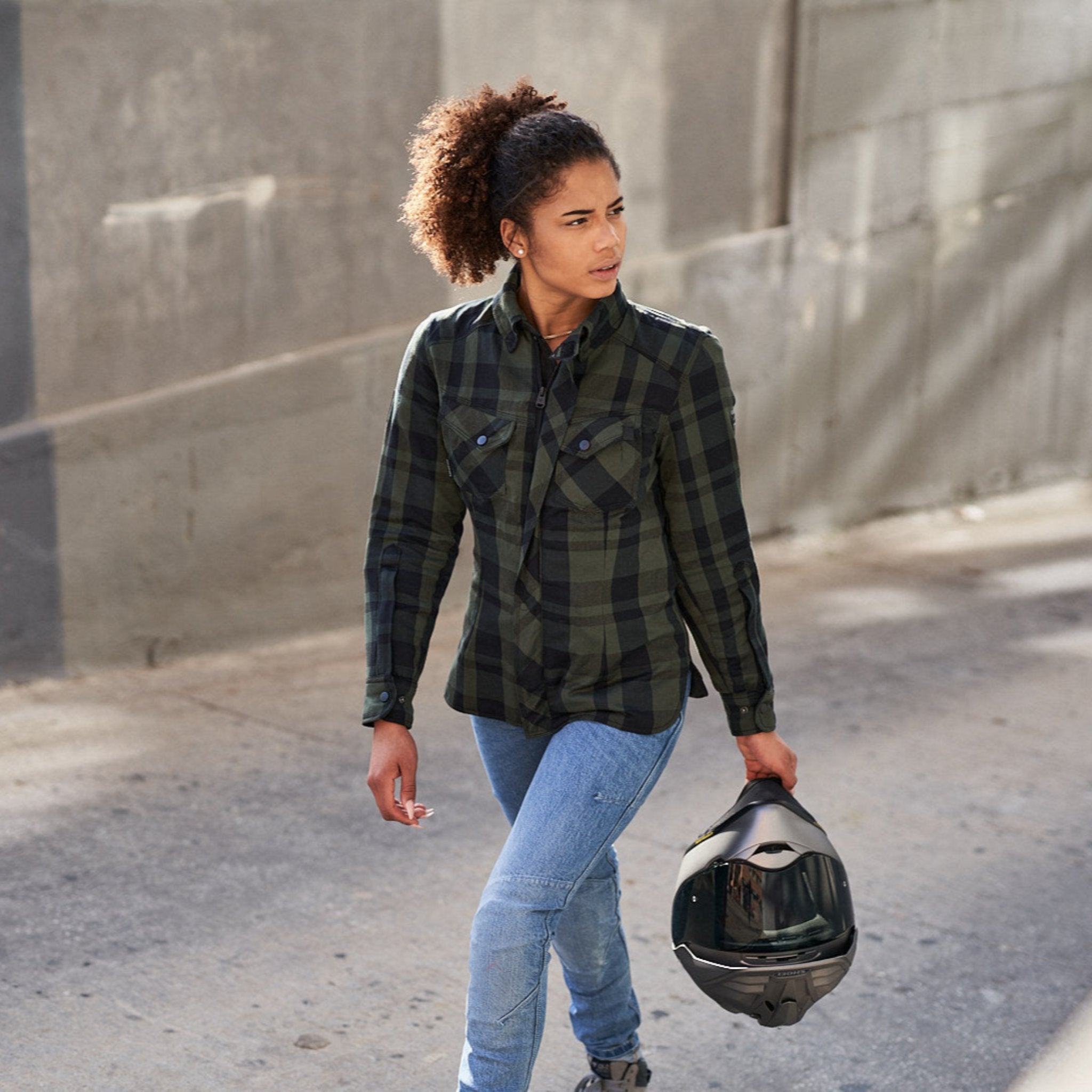 Young woman wearing Light blue motorcycle jeans and green shirt for women 