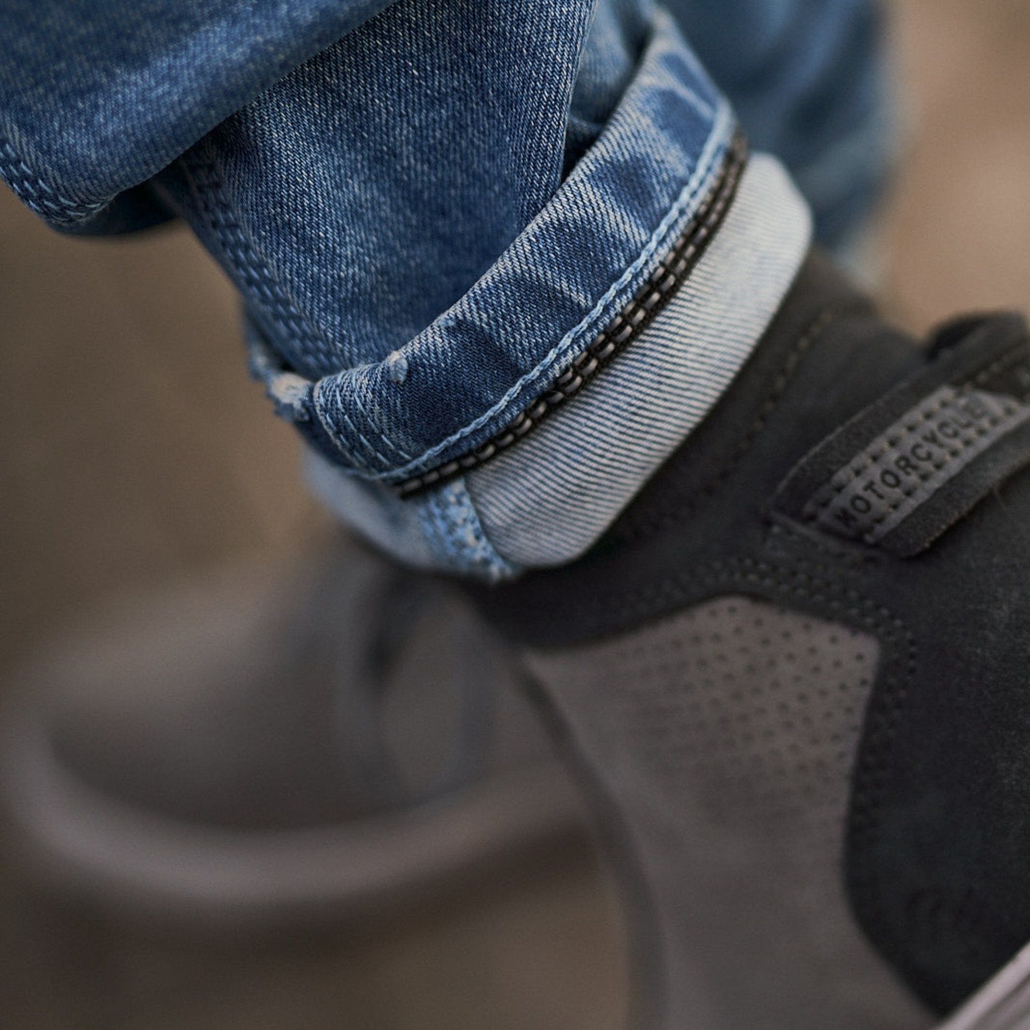 A close up of the motorcycle shoe and motorcycle jeans reflective stripe