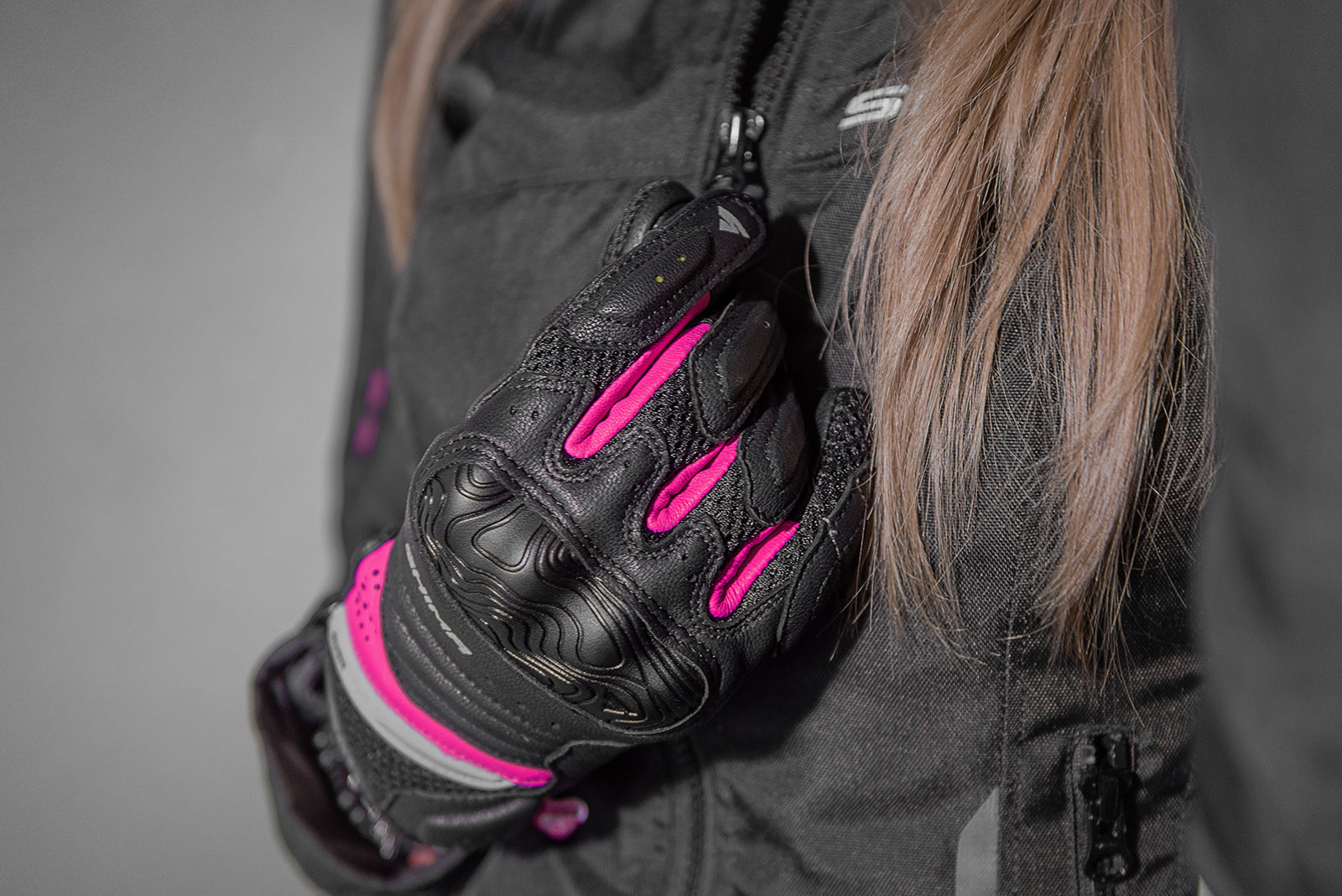 A close up of a woman&#39;s hand wearing Black and pink women&#39;s motorcycle gloves Rush lady  from Shima