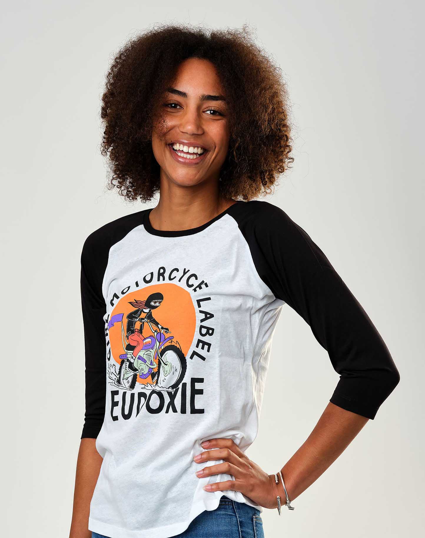 A young woman wearing black &amp; white baseball motorcycle t-shirt from Eudoxie 
