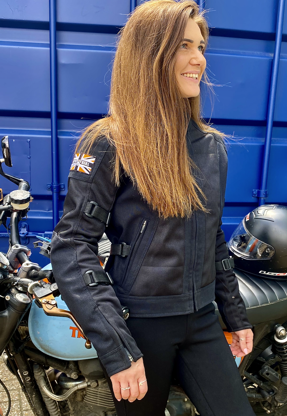 A smiling woman wearing Black summer mesh women&#39;s motorcycle jacket with Motogirl patch