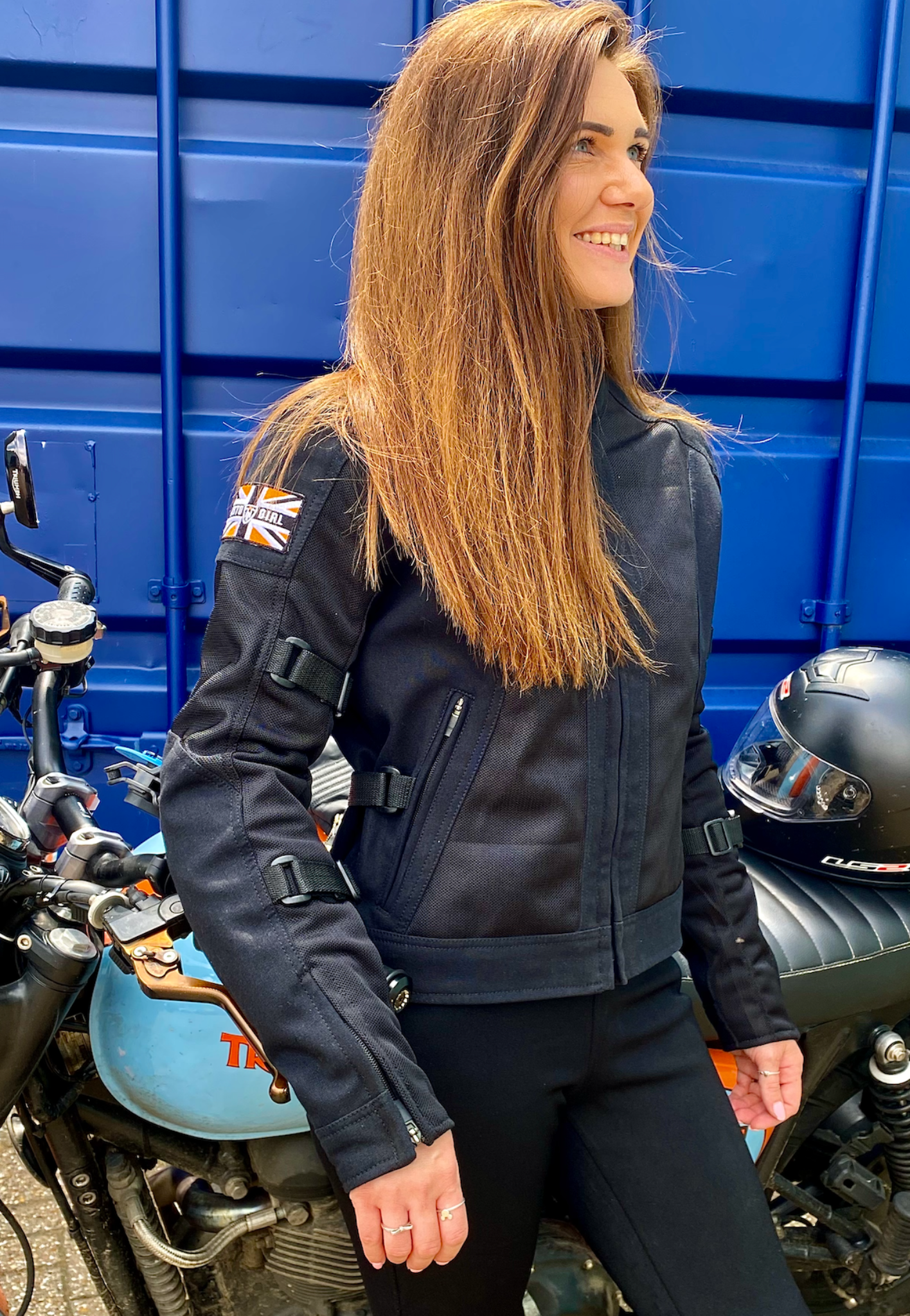 A smiling woman wearing Black summer mesh women's motorcycle jacket with Motogirl patch