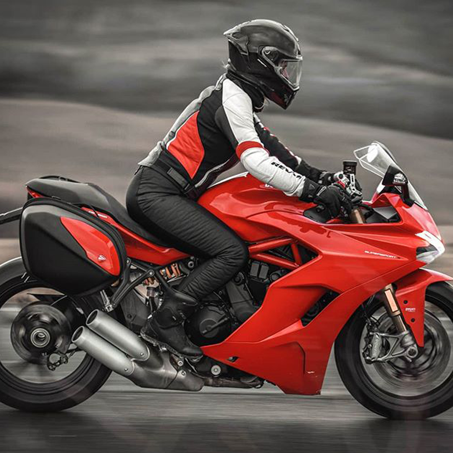 A woman on a red motorcycle wearing black women's motorcycle leggings from exagon66