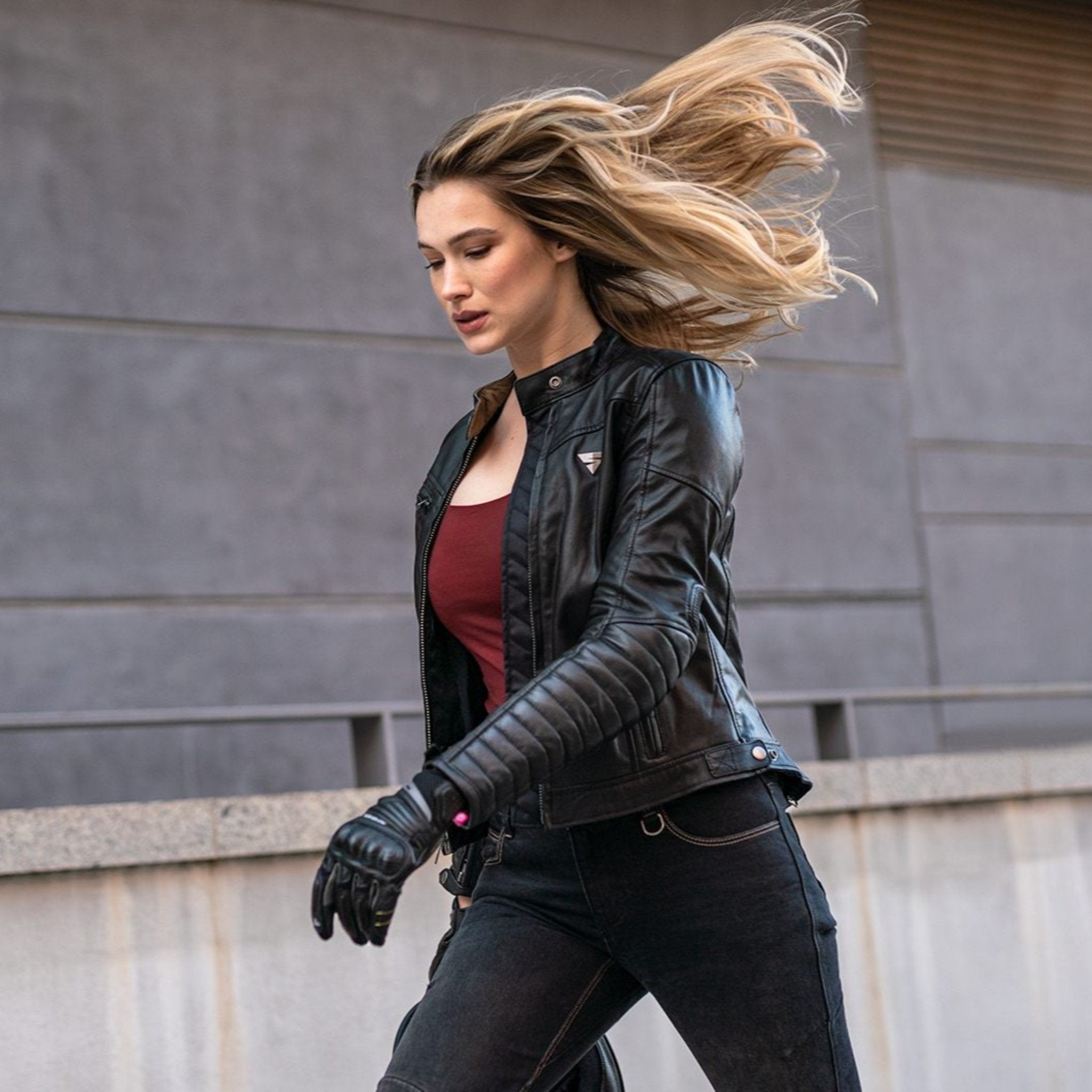 A blond woman  wearing Black leather motorcycle jacket for women from Shima